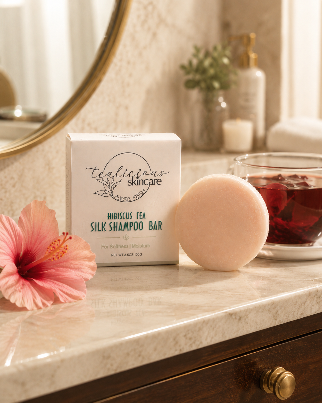 Hibiscus Tea & Silk Shampoo Bar by Tea-Licious Skincare beside hibiscus flower and brewed tea on a bathroom counter.