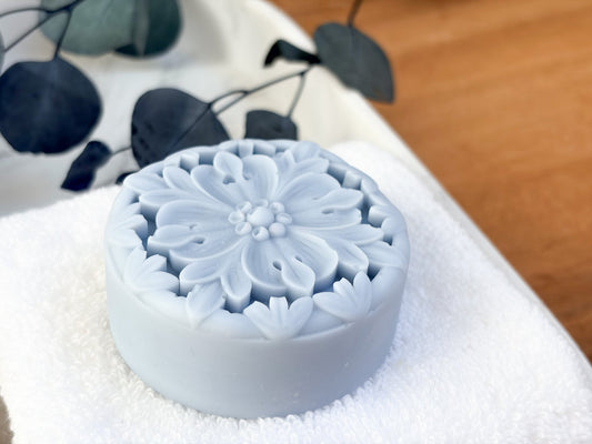 Floral solid lotion bar by Tea-licious Skincare on white towel