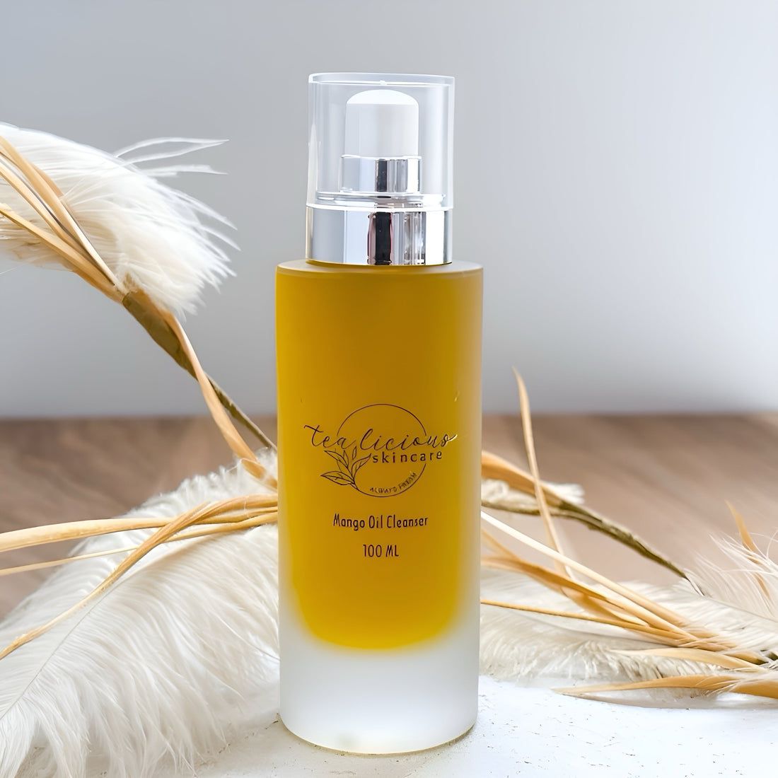 Tea-licious Skincare Baobab Tea Cleanser in frosted glass bottle with pump, photographed with soft botanicals in the background.