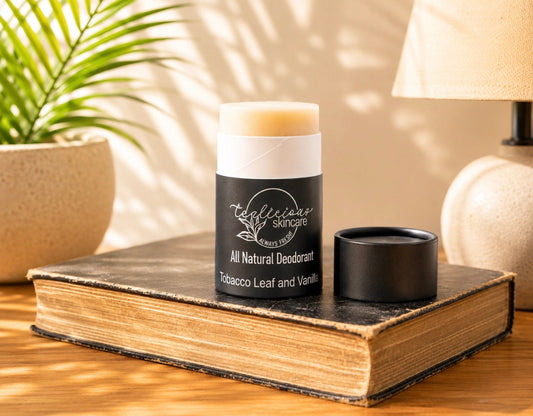 Tea-Licious baking-soda-free natural deodorant in a black compostable tube, displayed in warm natural light.