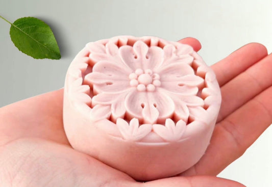 Tea-licious Skincare floral lotion bar held in hand — handcrafted pink flower design solid moisturizer