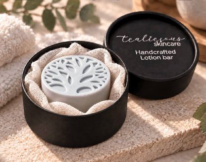 Sensuosi-Tea Men’s Satin-Glide Solid Lotion Stone in a black Tea-Licious Skincare container with soft gauze, styled in warm natural light with neutral spa-inspired accents.