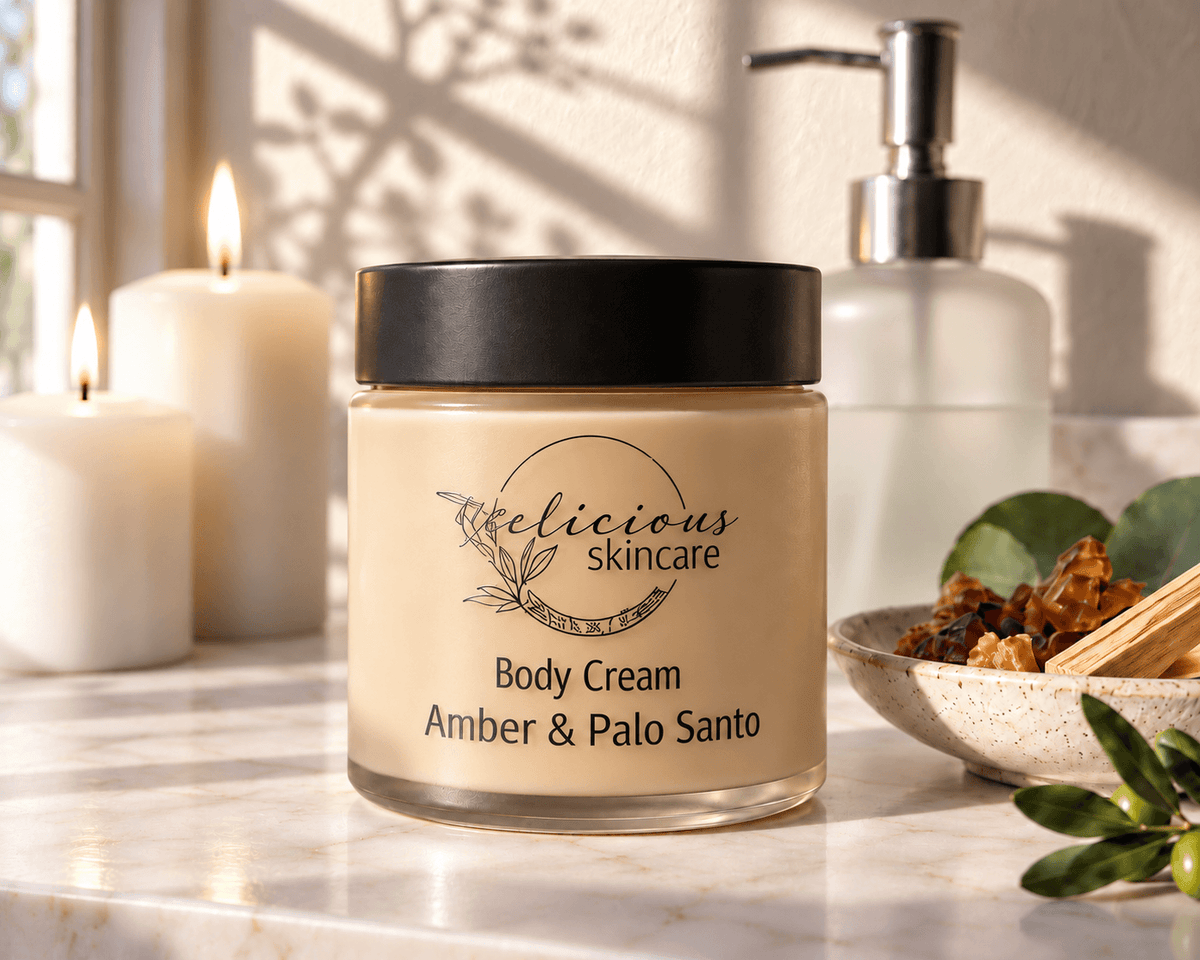 jar of Tea-licious Amber & Palo Santo Body Cream showing its light toffee colour on a stone counter top with candle in background 