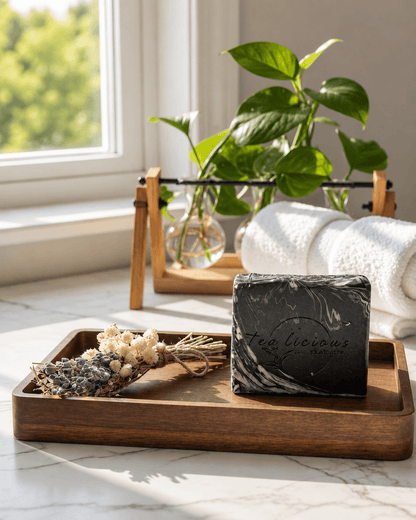Black Tea & Sandalwood tea-infused soap for men by Tea-licious Skincare with a black marble swirl design, styled on a wooden tray with natural botanicals.