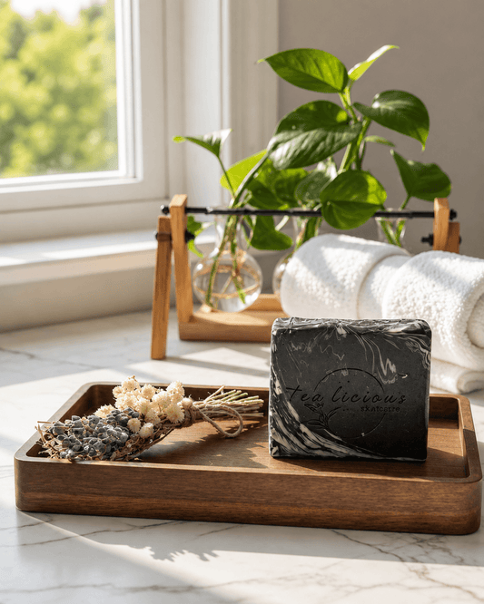Black Tea & Sandalwood tea-infused soap for men by Tea-licious Skincare with a black marble swirl design, styled on a wooden tray with natural botanicals.