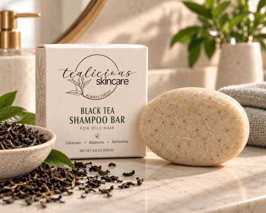 Black Tea Shampoo Bar for oily hair with beige oval shampoo bar, Tea-Licious Skincare box and loose black tea leaves.