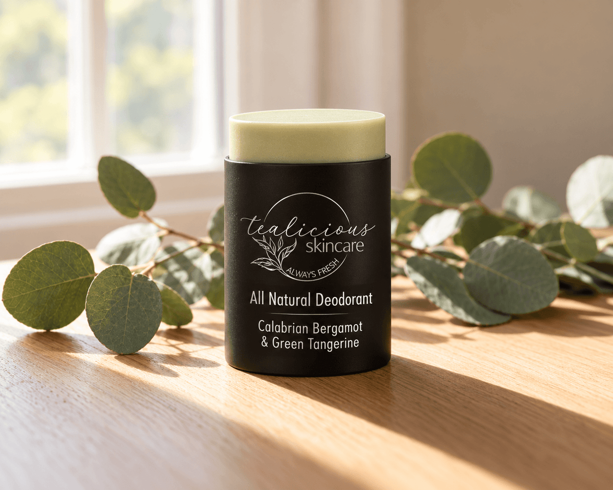 Tea-licious Calabrian Bergamot & Green Tangerine deodorant in a black oval container beside its matching lid, fresh citrus