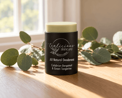 Tea-licious Calabrian Bergamot & Green Tangerine deodorant in a black oval container beside its matching lid, fresh citrus