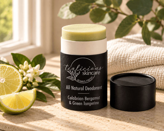 Tea-Licious Calabrian Bergamot & Green Tangerine all-natural deodorant with silver label text, fresh citrus, greenery and soft towels in warm natural light.