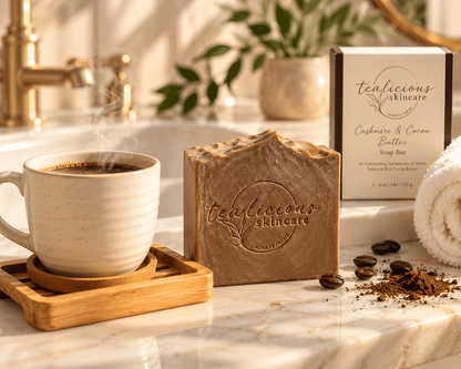 Cashmere & Cocoa Butter handcrafted soap beside a steaming cup of coffee in a warm, upscale bathroom setting.