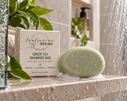 Woman using Tea-Licious Black Tea Shampoo Bar for oily hair in the shower, working the solid bar through wet hair with a rich foamy lather.