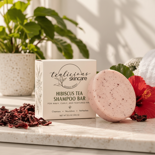 
Tea-Licious Hibiscus Tea Shampoo Bar for wavy, curly and textured hair beside its cream box with hibiscus flower and dried hibiscus petals.