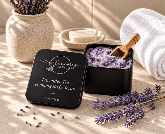     Tea-Licious Lavender Tea Foaming Body Scrub displayed with lavender, white towels and spa accessories in warm natural light.