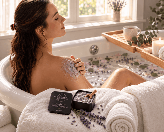     Woman relaxing in a bath while using Tea-Licious Lavender Tea Foaming Body Scrub beside the tub.