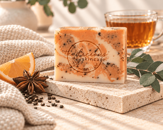 Tea-Licious Mulled Orange Cider Tea Soap Bar styled with an orange wedge, star anise, tea and eucalyptus in warm natural light.