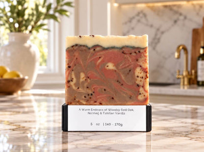 Tea-Licious Red Oak, Nutmeg & Tahitian Vanilla Soap displayed beside a marble sink with warm brass fixtures and soft natural light.
