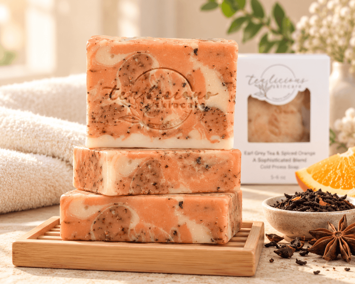 Three stacked Tea-licious Spiced Orange Tea Soap Bars on a bamboo rack with orange, tea leaves and warm spice accents.