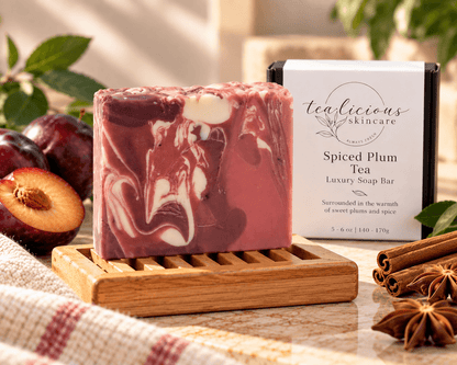 Spiced Plum Tea luxury soap bar with rich plum and cream swirls, displayed on a bamboo soap dish beside its Tea-Licious Skincare box with warm spices and soft natural light.