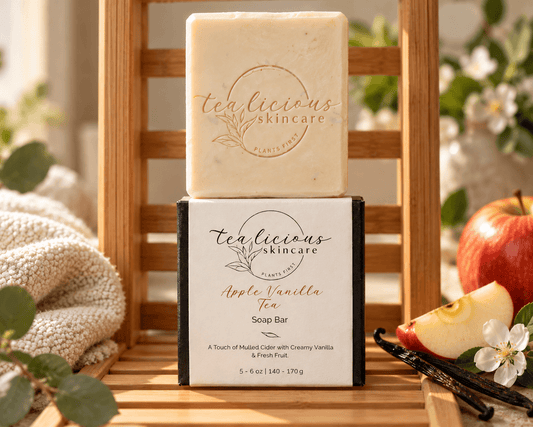 Tea-licious Apple Vanilla Tea Soap Bar displayed on its box on a bamboo shelf beside cream towels, apples and vanilla pods.