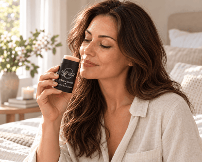 Tea-licious Bergamot Rose & Lavender deodorant in a black oval container with silver lettering, lady holding deodorant smelling scent