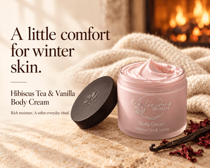 Tea-licious Hibiscus Tea & Vanilla Body Cream beside hibiscus petals and vanilla pods, with a fireplace and the headline “A little comfort for winter skin.”