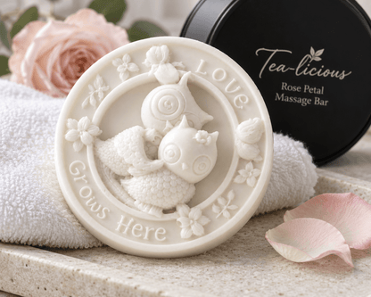 Close-up of round botanical massage bar embossed with two owls and Love Grows Here resting on a white textured towel.