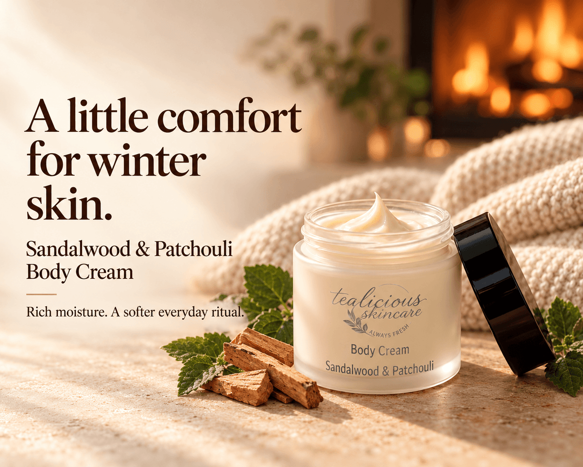 Tea-licious Sandalwood & Patchouli Body Cream beside sandalwood and green leaves, with a cozy fireplace and the headline “A little comfort for winter skin.