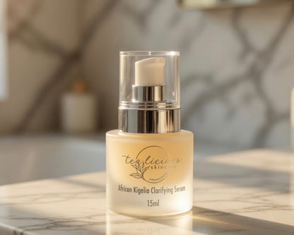 Tea-licious African Kigelia Clarifying Serum on marble vanity in warm spa bathroom lighting