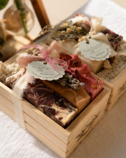 Tea-infused artisan soap gift crates with botanical accents and sisal pouches in warm sunlight.