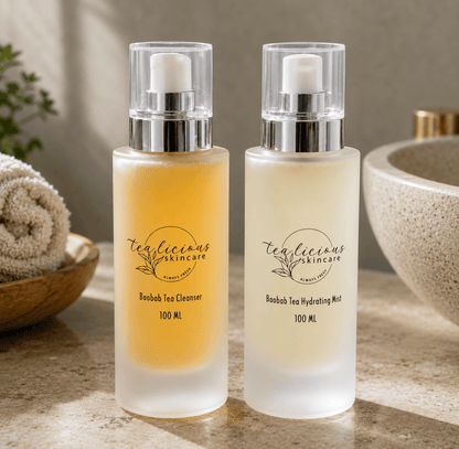 Tea-licious Baobab Tea Cleanser and Hydrating Mist displayed on elegant bathroom counter in soft light