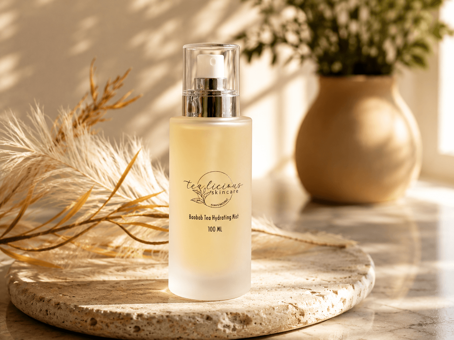Baobab Tea Hydrating Mist on stone tray with botanicals in warm natural morning sunlight scene.