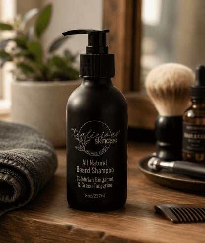 Tea-licious beard shampoo on men’s vanity with grooming tools in warm natural morning light scene.