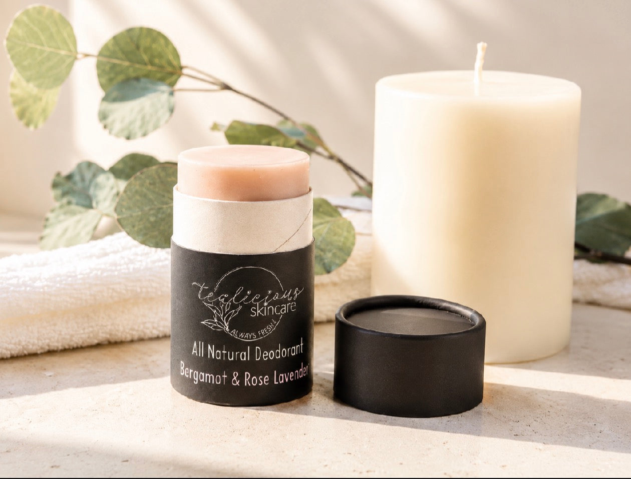 Tea-licious Skincare Bergamot & Rose Lavender baking soda free deodorant displayed with a candle in a clean, high-end lifestyle aesthetic.