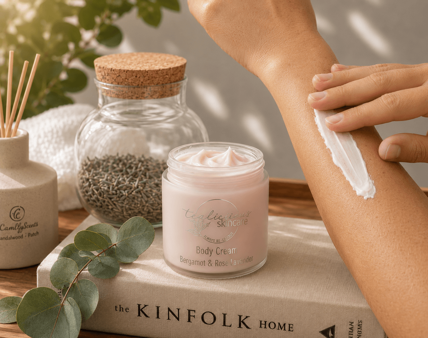 Woman applying Bergamot Rose & Lavender body cream with silver label in warm natural sunlight.