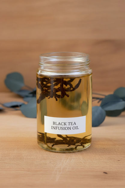 Black tea leaves steeping in oil infusion for Tea-licious skincare handcrafted botanical formulations.