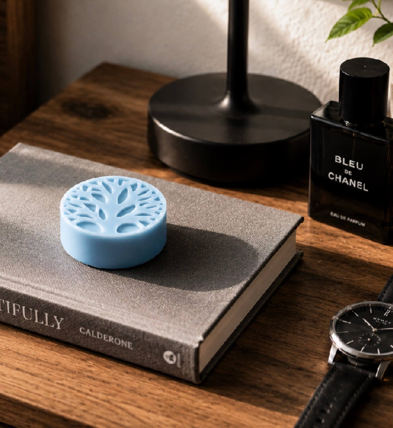 Blue Tea-Licious solid lotion bar with watch and cologne in a masculine grooming setting.