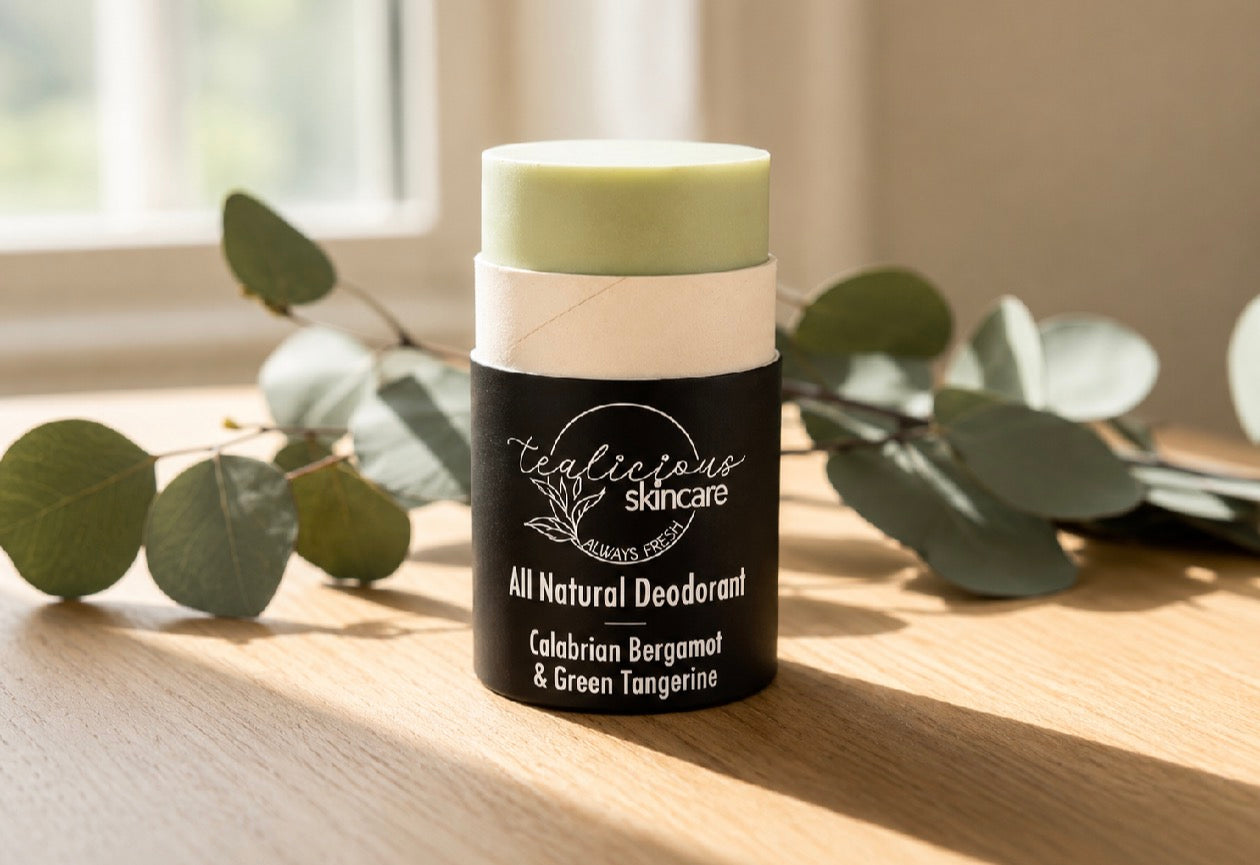 Tea-licious Skincare Calabrian Bergamot & Green Tangerine baking soda free deodorant displayed on a wooden surface with a soft-focus botanical background.