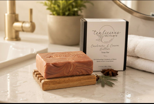 Cashmere & Cocoa Butter tea-infused soap bar with packaging on bathroom counter beside towel