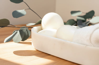Fragrance-free Tea-licious soap bars with eucalyptus leaves and soft towel in warm sunlight.