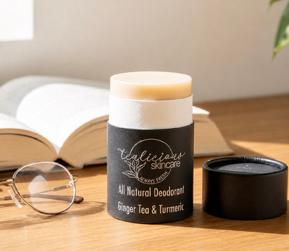 Tea-licious Skincare Ginger Tea & Turmeric baking soda free deodorant placed on a desk next to an open book and glasses, capturing a serene lifestyle aesthetic.