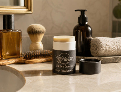 Tea-licious Skincare Ginger Tea & Turmeric baking soda free deodorant styled on a bathroom vanity with grooming essentials.