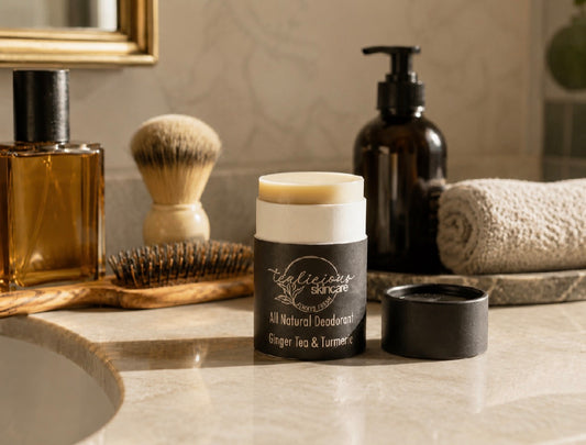 Tea-licious Skincare Ginger Tea & Turmeric baking soda free deodorant styled on a bathroom vanity with grooming essentials.
