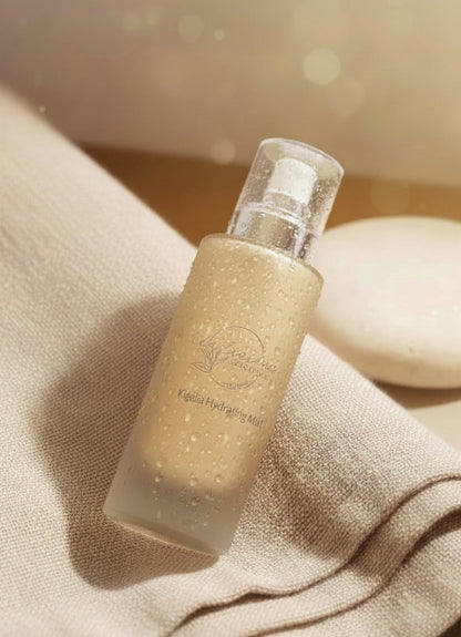 Tea-licious Kigelia Hydrating Mist with dewy bottle on soft linen in warm luxury skincare setting