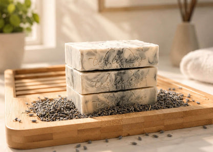 Stack of tea-infused lavender soap bars on wooden tray with lavender buds in soft morning light.
