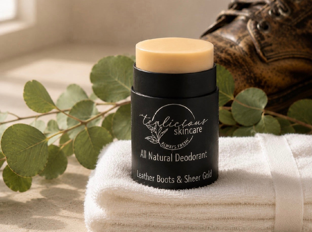 Close-up of Tea-licious Skincare Leather Boots & Sheer Gold baking soda free deodorant positioned next to a vintage leather boot and greenery.