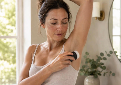 A woman applying Tea-licious Skincare baking soda free deodorant, highlighting natural skin texture.