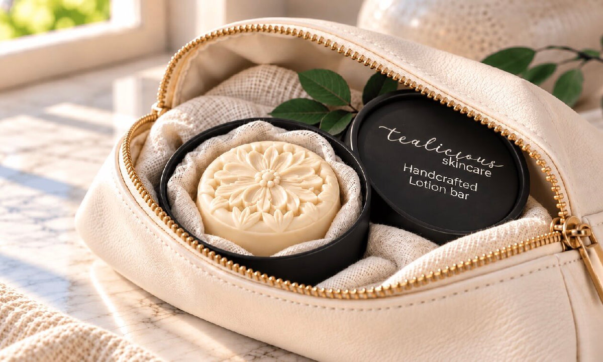 Woman holding an intricately carved cream-colored solid lotion bar beside a cup of tea and loose tea leaves in warm natural light.