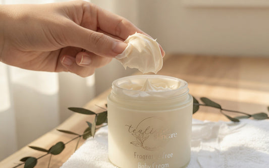 Hand holding a cream above an open jar of cream with 'tali' branding.