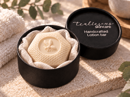 Wild Honey Solid Lotion Bar with a honeycomb and bee design nestled in soft gauze inside a black Tea-Licious Skincare container, styled in warm natural light with neutral spa-inspired accents.